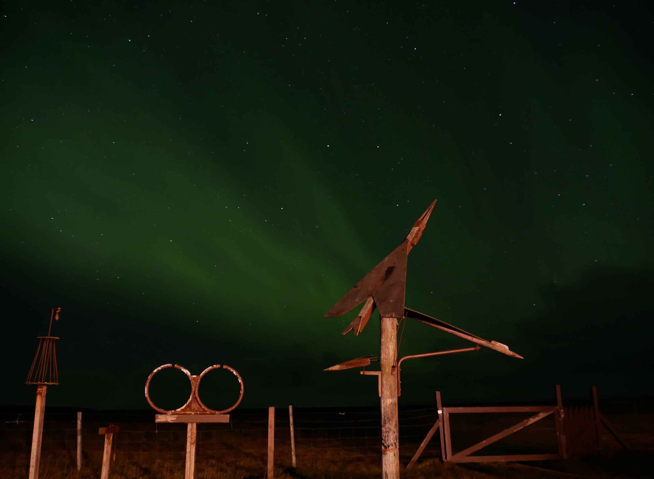 Northern Lights and sculptures in our yard at Cosyness Cottage, Hafnir