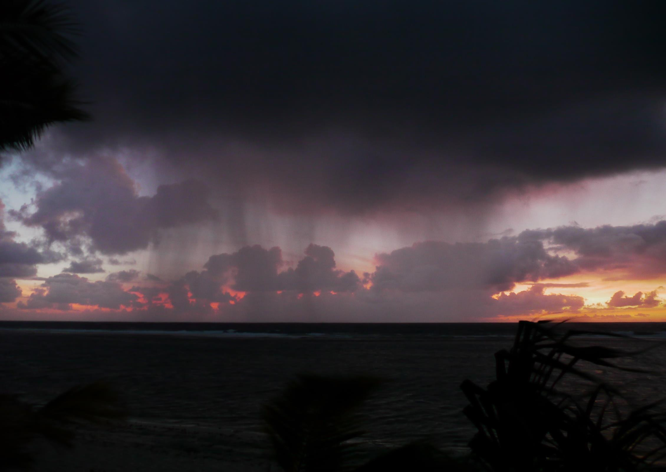 A curtain of rain falls on our final sunset in Tonga